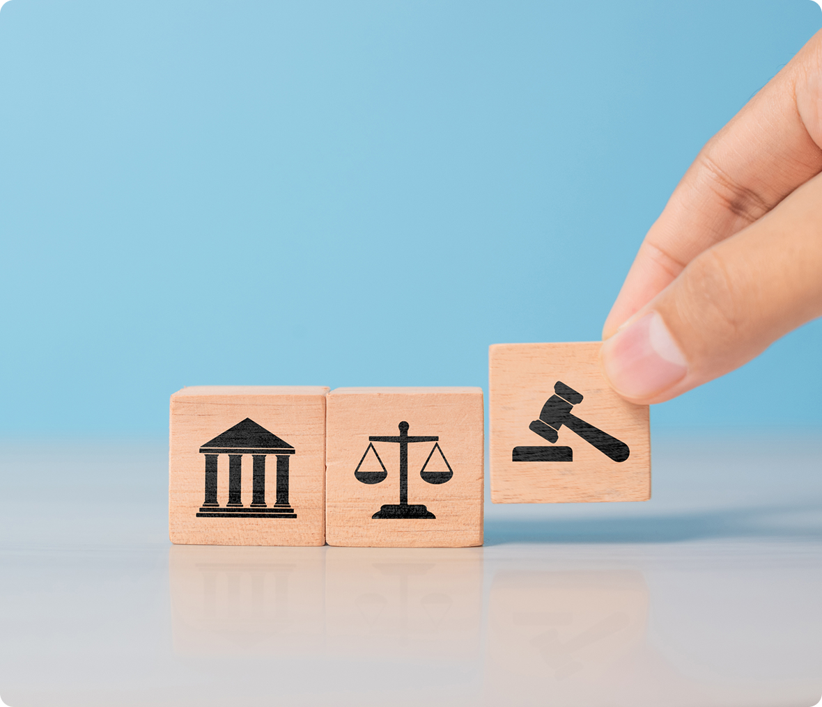 Blocks depicting legal symbols with hand.